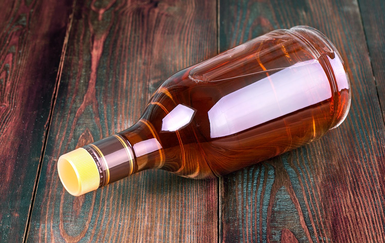 Bouteille d’alcool à 90 posée avec des ingrédients pour préparer une liqueur maison.